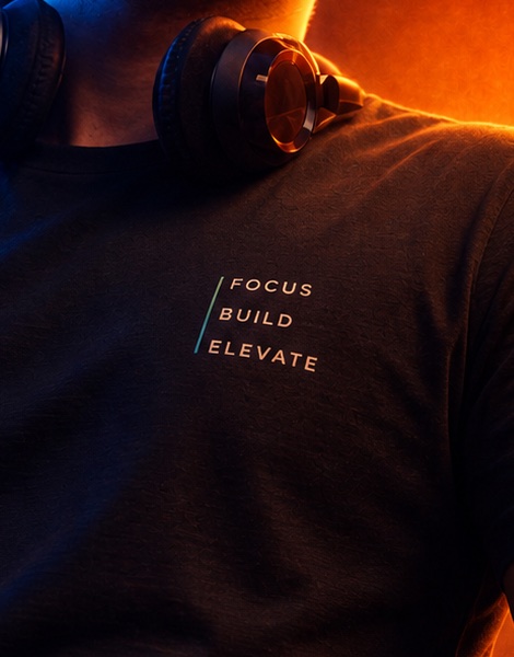 Close crop of the portrait: a dark t-shirt printed with the words Focus, Build, Elevate.